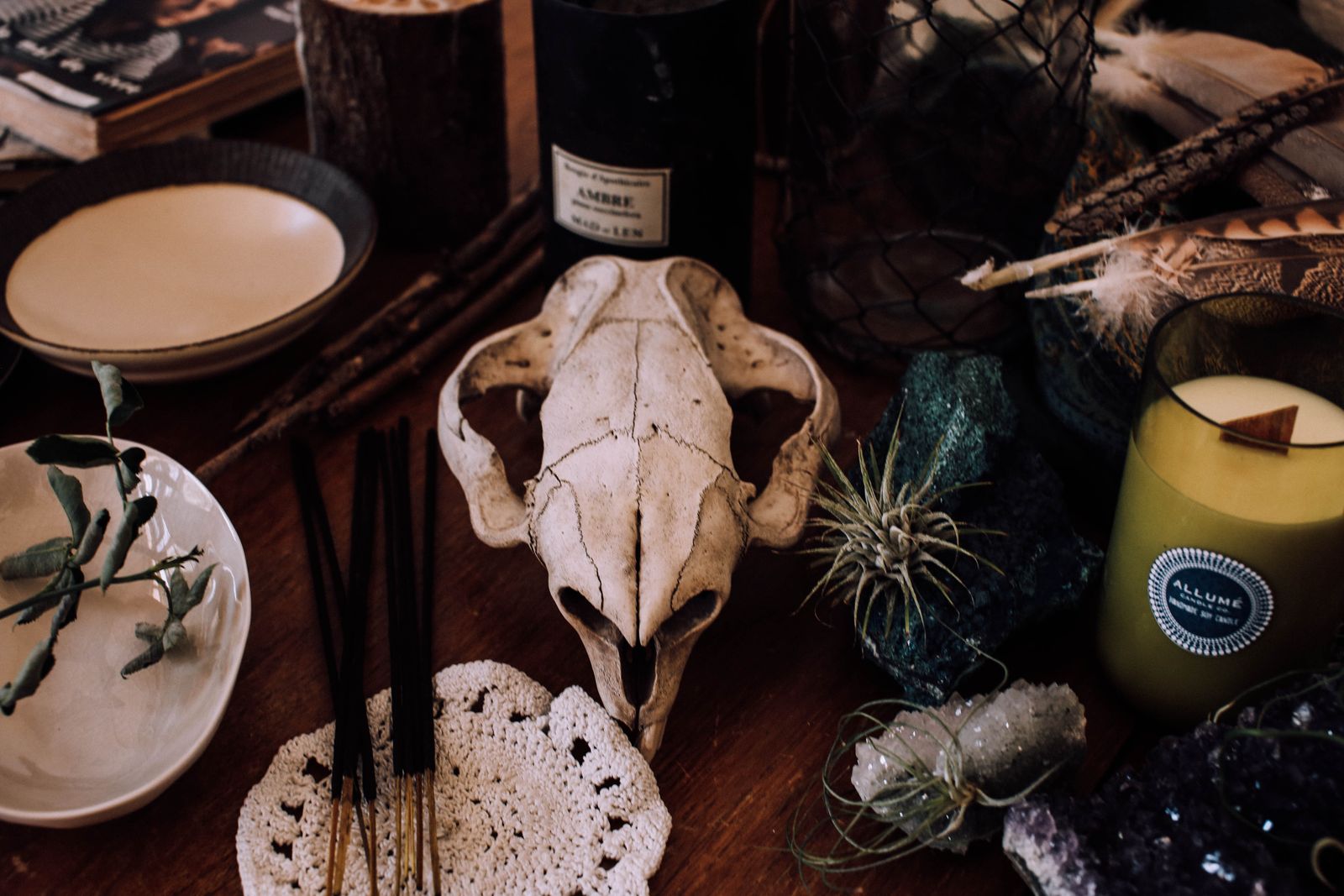 Composição ritual com caveira decorativa, cristais e incenso