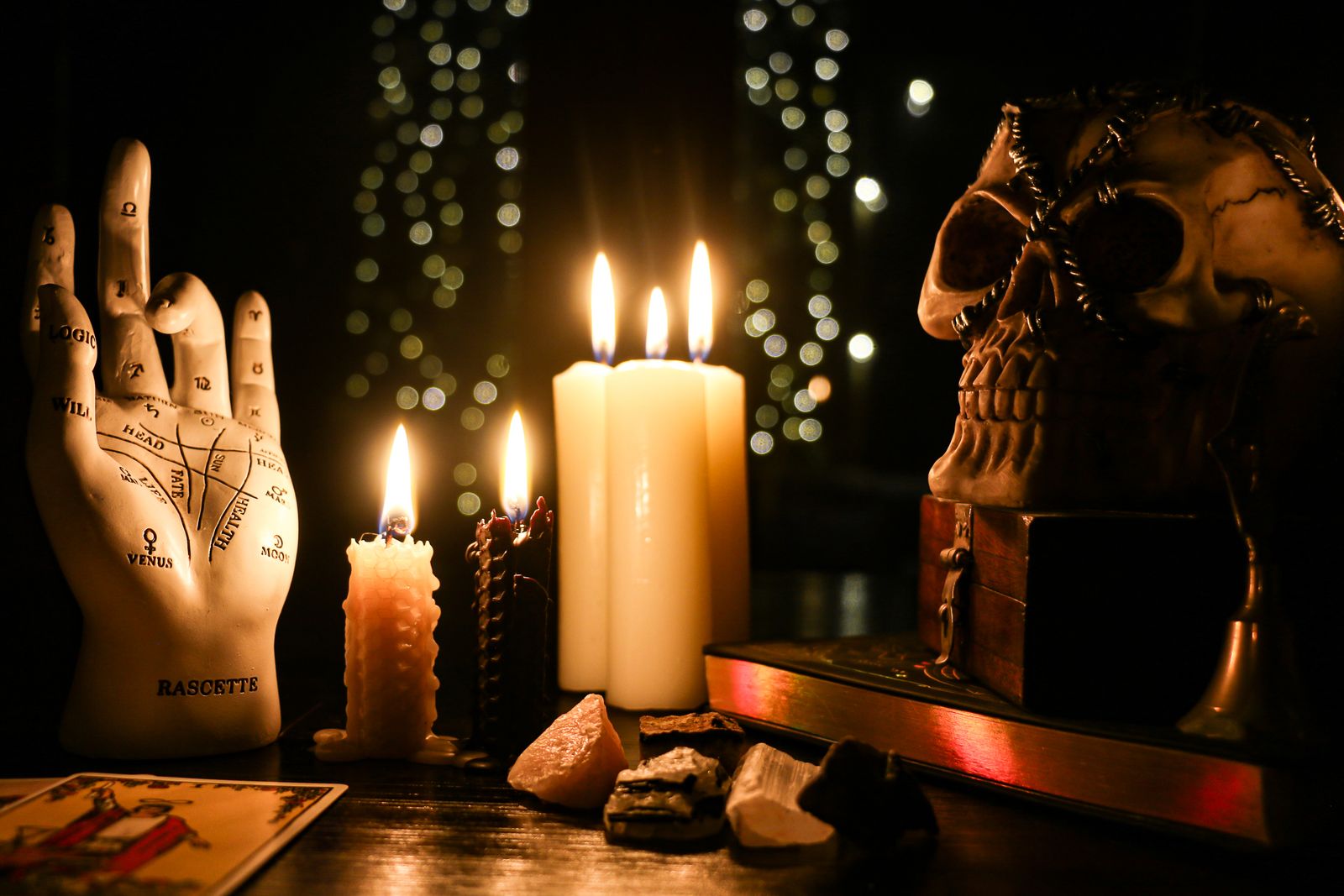 Altar escuro com velas, mão de quiromancia e caveira decorativa